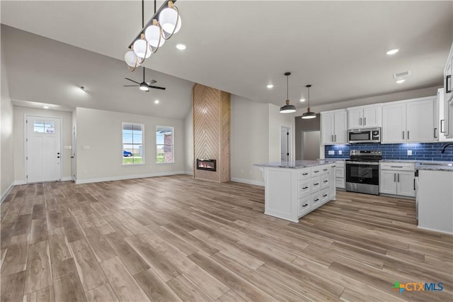 1811 Ember Dr, Temple, TX 76502 - kitchen with appliances with stainless steel finishes, a ceiling fan, open floor plan, a kitchen island, and white cabinetry