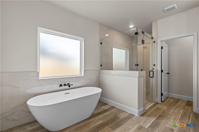 1811 Ember Dr, Temple, TX 76502 - bathroom featuring tile walls, a soaking tub, a shower stall, and wood finished floors