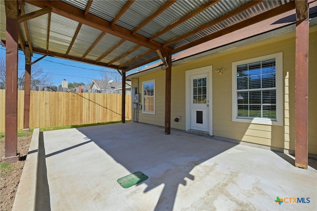 view of patio / terrace featuring fence and a carport