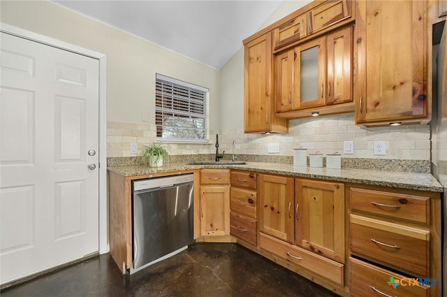 kitchen with lofted ceiling, brown cabinets, light stone countertops, stainless steel dishwasher, and a sink