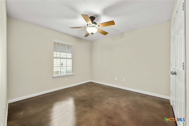 unfurnished room with concrete flooring, a ceiling fan, and baseboards