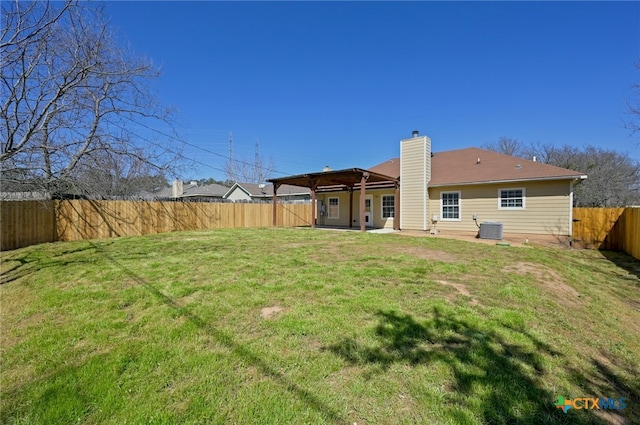 rear view of house featuring a lawn, a fenced backyard, a chimney, central air condition unit, and a patio area