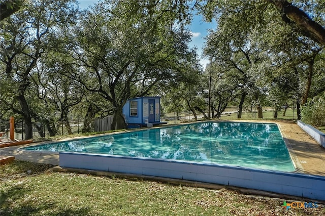 view of pool featuring an outdoor structure, fence, and a fenced in pool