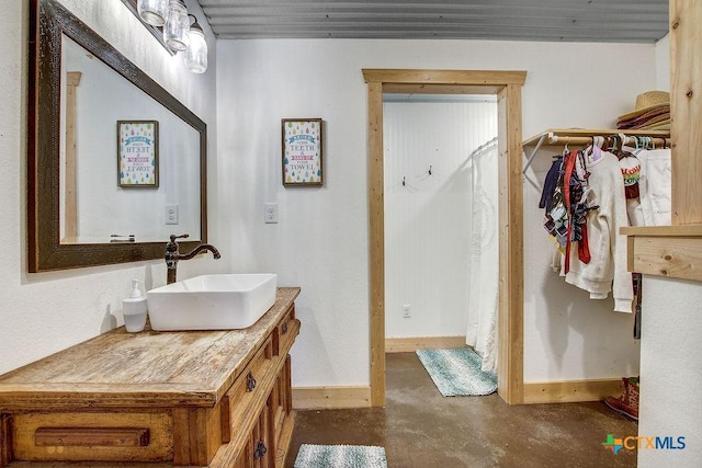 bathroom featuring vanity, concrete flooring, and baseboards