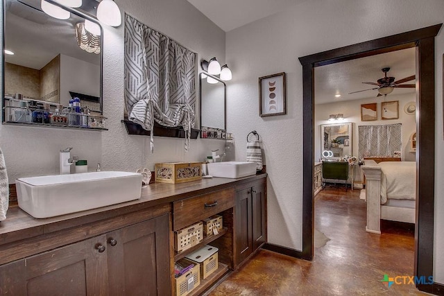 bathroom featuring finished concrete floors, ensuite bathroom, baseboards, and a sink