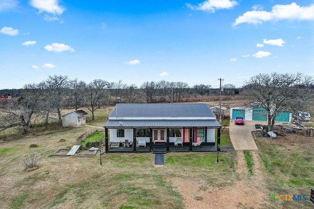 view of front of house with a porch, metal roof, and a front lawn