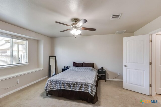 bedroom featuring baseboards, visible vents, and light carpet