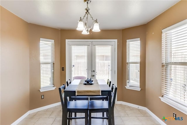 dining room with a notable chandelier, baseboards, and light tile patterned floors