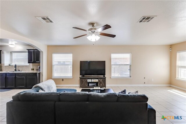 living room featuring visible vents, arched walkways, and light tile patterned flooring