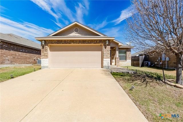 view of front of home with stone siding, concrete driveway, a garage, brick siding, and central AC unit