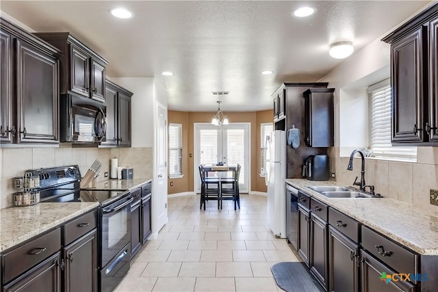 kitchen featuring tasteful backsplash, dark brown cabinets, black appliances, and a sink