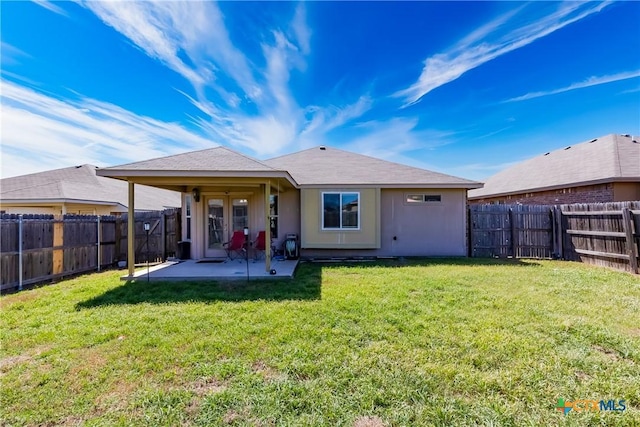 rear view of property with a patio area, a lawn, and a fenced backyard