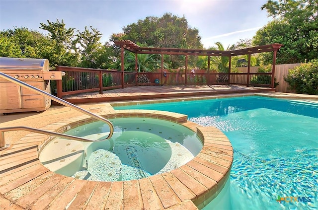 view of swimming pool with a grill and an in ground hot tub