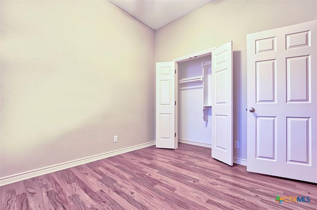 unfurnished bedroom featuring light wood-type flooring and a closet