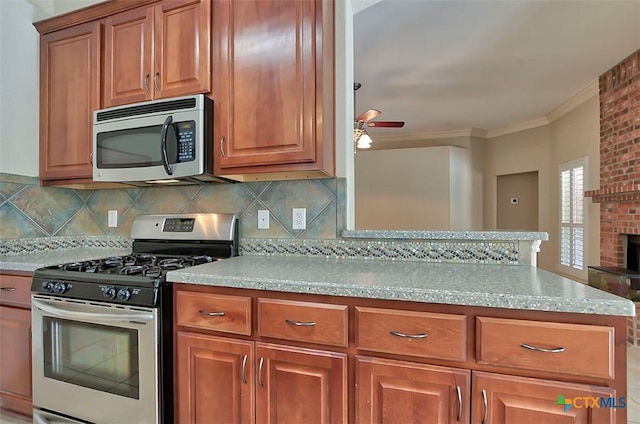 kitchen with light stone countertops, stainless steel appliances, decorative backsplash, ornamental molding, and ceiling fan