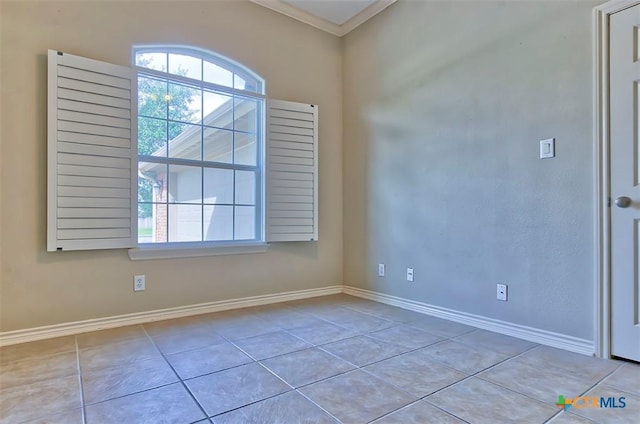 tiled empty room featuring crown molding