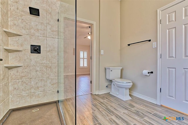 bathroom featuring toilet, ceiling fan, and tiled shower