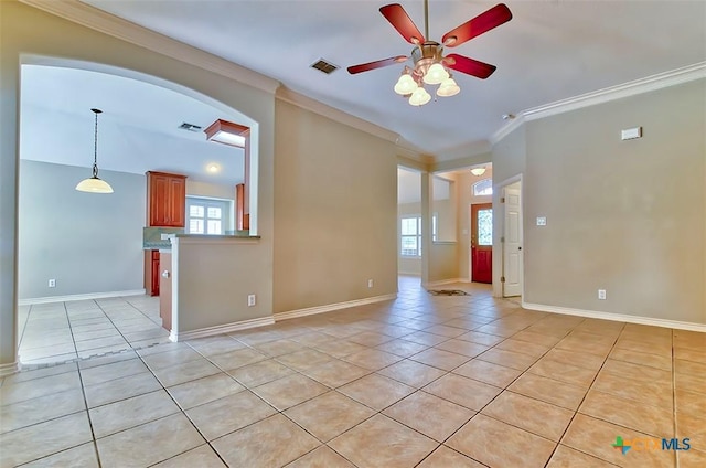 tiled empty room featuring ceiling fan and crown molding