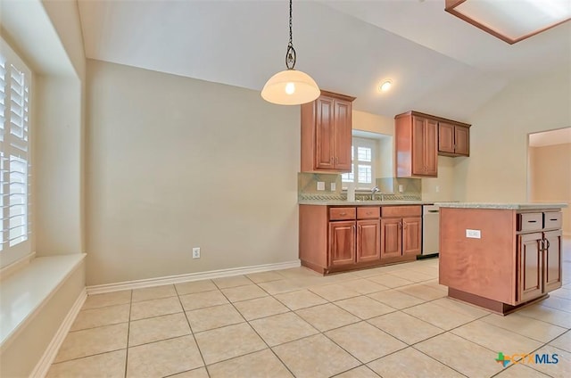 kitchen with dishwasher, lofted ceiling, decorative light fixtures, sink, and light tile patterned floors