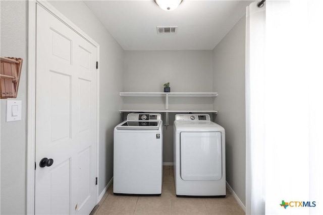 514 Eden Ranch Dr, Canyon Lake, TX 78133 - laundry area with washing machine and clothes dryer and light tile patterned flooring