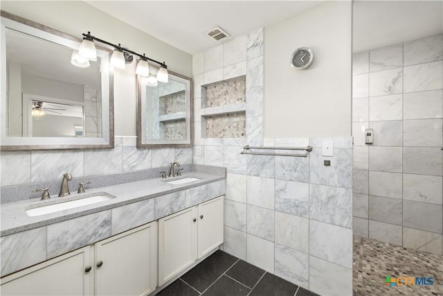 514 Eden Ranch Dr, Canyon Lake, TX 78133 - bathroom featuring tile walls, double vanity, tile patterned flooring, a ceiling fan, and walk in shower
