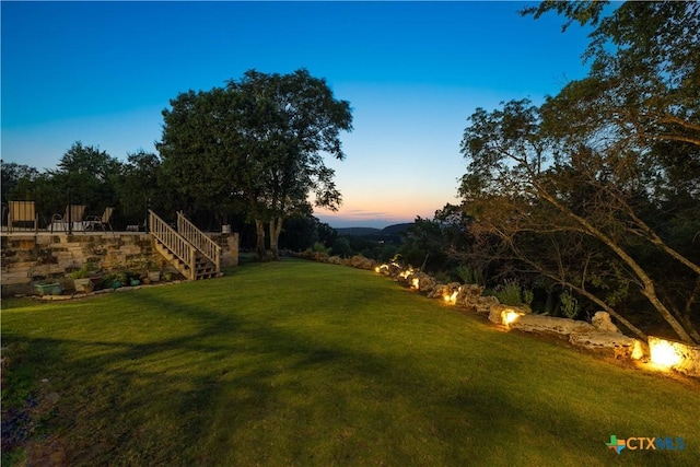 514 Eden Ranch Dr, Canyon Lake, TX 78133 - yard at dusk featuring a lawn