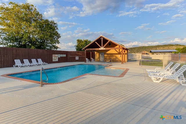 view of swimming pool with a mountain view and a patio area