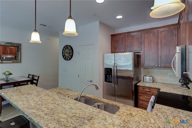 kitchen featuring stainless steel appliances, sink, light stone counters, decorative light fixtures, and decorative backsplash