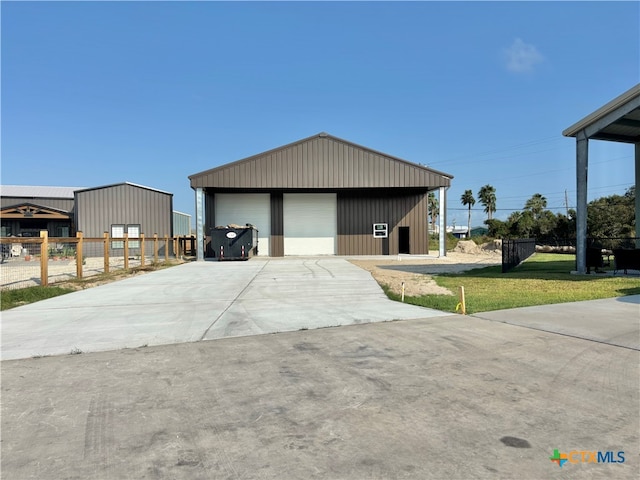 view of front of home featuring a garage, a front lawn, and an outdoor structure