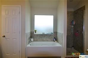 bathroom with a shower stall and a garden tub