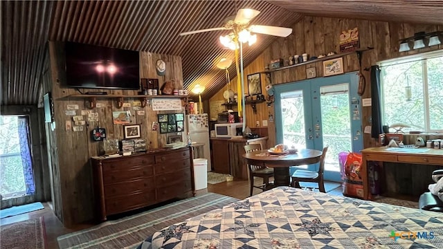 bedroom with access to outside, french doors, wood walls, and lofted ceiling