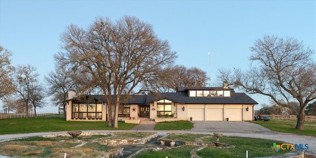 view of front of house with a garage and a front lawn