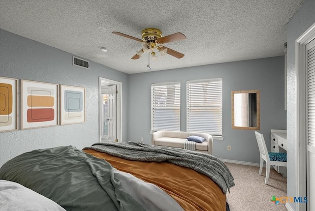 carpeted bedroom featuring ceiling fan and a textured ceiling