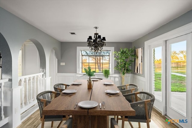 dining room with plenty of natural light, a chandelier, and light wood-type flooring