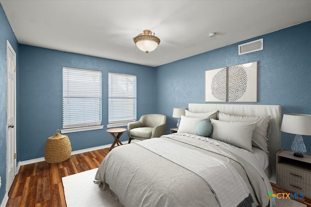 bedroom with dark hardwood / wood-style flooring