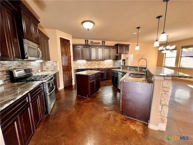 kitchen with appliances with stainless steel finishes, decorative light fixtures, dark brown cabinets, sink, and an island with sink