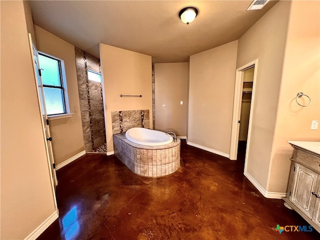 bathroom featuring vanity, independent shower and bath, and concrete floors