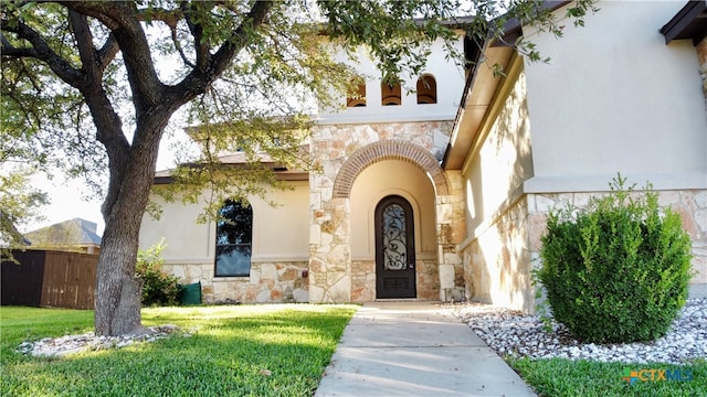 entrance to property featuring a lawn