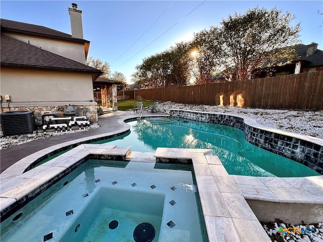 snow covered pool with central AC and an in ground hot tub