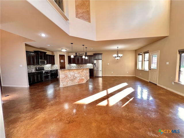 unfurnished living room with a towering ceiling and a chandelier