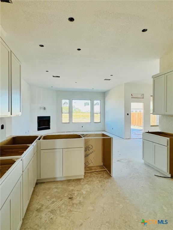 kitchen featuring a textured ceiling, a wealth of natural light, and cream cabinets