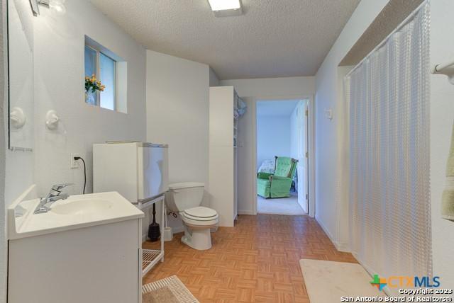 1254 Village Shore Dr, Canyon Lake, TX 78133 - bathroom featuring toilet, a textured ceiling, and vanity