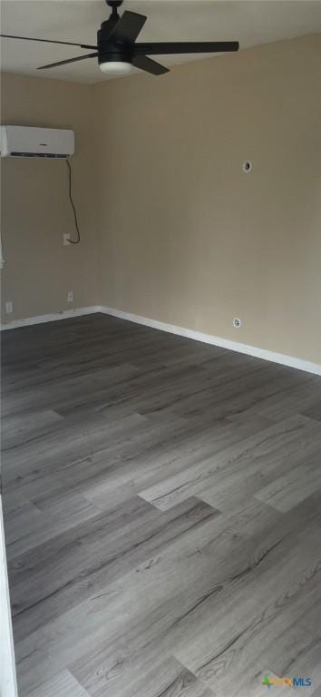704 E Ave N, Temple, TX 76504 - empty room with an AC wall unit, ceiling fan, wood finished floors, and baseboards