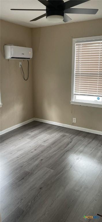 704 E Ave N, Temple, TX 76504 - spare room with a wall unit AC, ceiling fan, wood finished floors, and baseboards