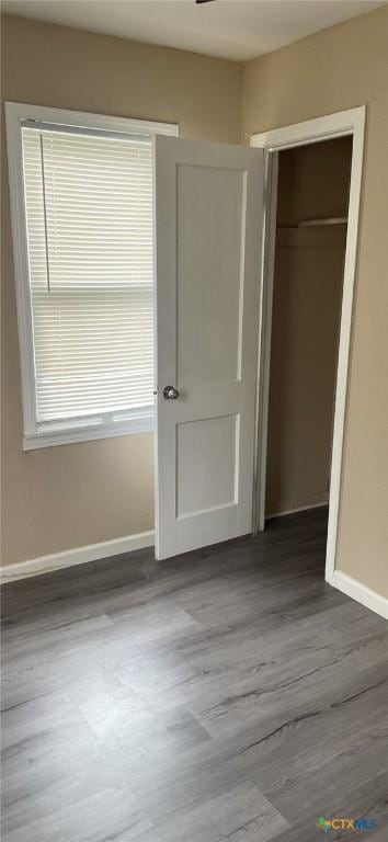 704 E Ave N, Temple, TX 76504 - unfurnished bedroom featuring baseboards, wood finished floors, and a closet