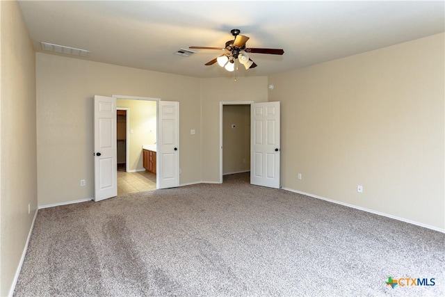 unfurnished bedroom featuring baseboards, visible vents, and light colored carpet