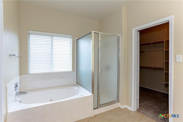 bathroom with a garden tub, tile patterned flooring, a shower stall, and a walk in closet