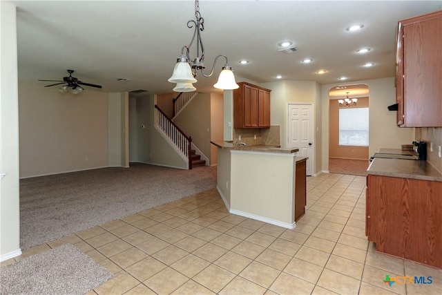 kitchen featuring light tile patterned flooring, light carpet, stove, visible vents, and decorative backsplash