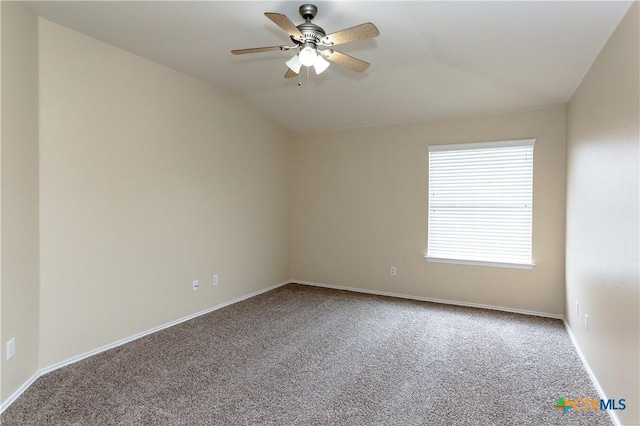 carpeted empty room featuring a ceiling fan, vaulted ceiling, and baseboards