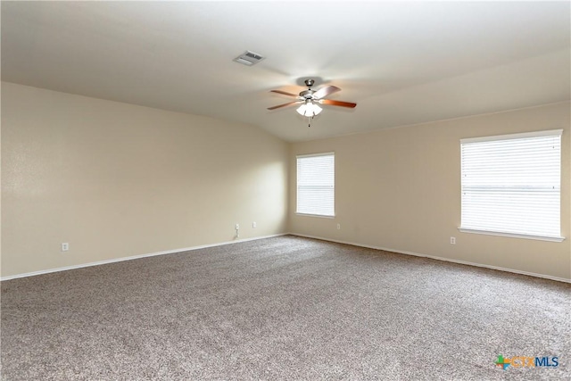 carpeted spare room with baseboards, visible vents, and a ceiling fan